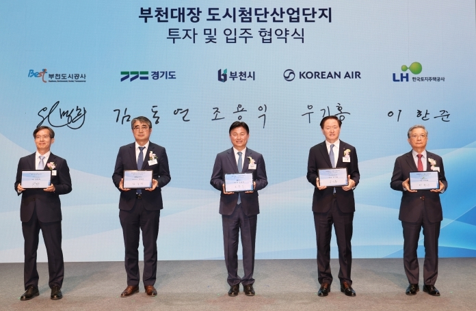 조용익 부천시장(가운데)을 비롯한 부천도시공사-경기도-부천시-대한항공-한국토지주택공사(LH) 등 5개 기관 대표자들이 서명을 마친 후 협약서가 담긴 태블릿을 들고 기념 촬영을 하고 있다.