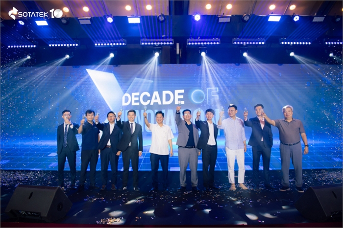 경영진과 손님들이 함께 건배하며 SotaTek의 10주년을 축하하고 있다.