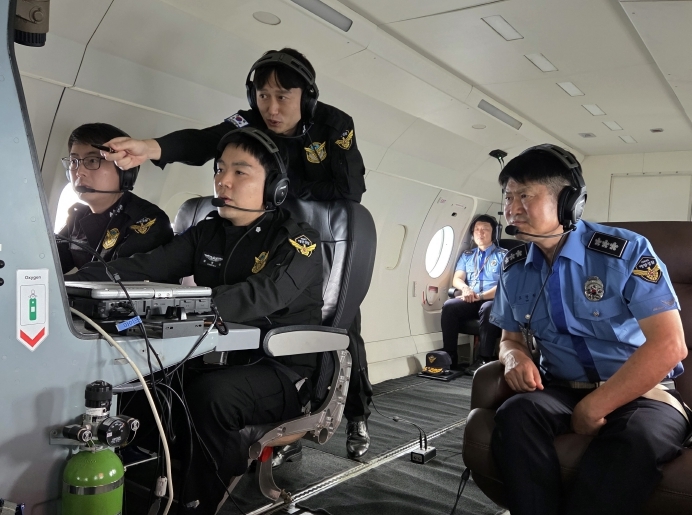 항공 레이더를 통해 외국어선의 동향을 설명 중인 항공단장과 이를 청취 중인 중부해경청장