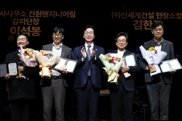 정명근 화성특례시장이 화성예술의 전당 개관기념 제야 콘서트에서 유공자들에게 특별 공로패 및 감사패를 전라하고 기념촬영을 하고 있다.